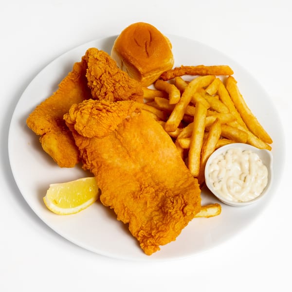 US Fried Chicken's fried fish and chicken tenders with fries, a roll, lemon, and tartar sauce.
